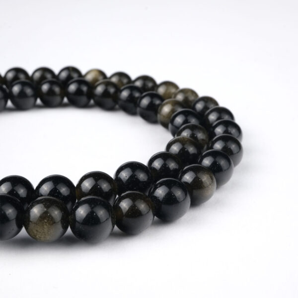 Gold Obsidyen doğal taş dizi 6 mm – siyah zemin üzerinde altın ışıltılarıyla koruma, denge ve enerji gücü sağlayan toptan doğal taş dizi