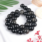 Silver Obsidyen doğal taş dizi 14 mm – siyah zemin üzerinde gümüşi parlak yansımalarıyla koruma, farkındalık ve enerji temizliği sağlayan toptan doğal taş dizi