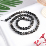 Silver Obsidyen doğal taş dizi 6 mm – siyah zemin üzerindeki gümüş ışıltılarıyla koruma, farkındalık ve enerji temizliği sağlayan toptan doğal taş dizi