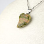 Unakit doğal taş kolye – yeşil ve pembe tonlarıyla sevgi, denge ve uyum enerjisi. Unakit kolye – doğanın sakinleştirici enerjisini taşıyan zarif bir takı. Pembe-yeşil unakit kolye – ruhsal huzuru artıran doğal taş aksesuar. Toptan doğal taş kolye – estetik görünüm ve pozitif enerji bir arada.