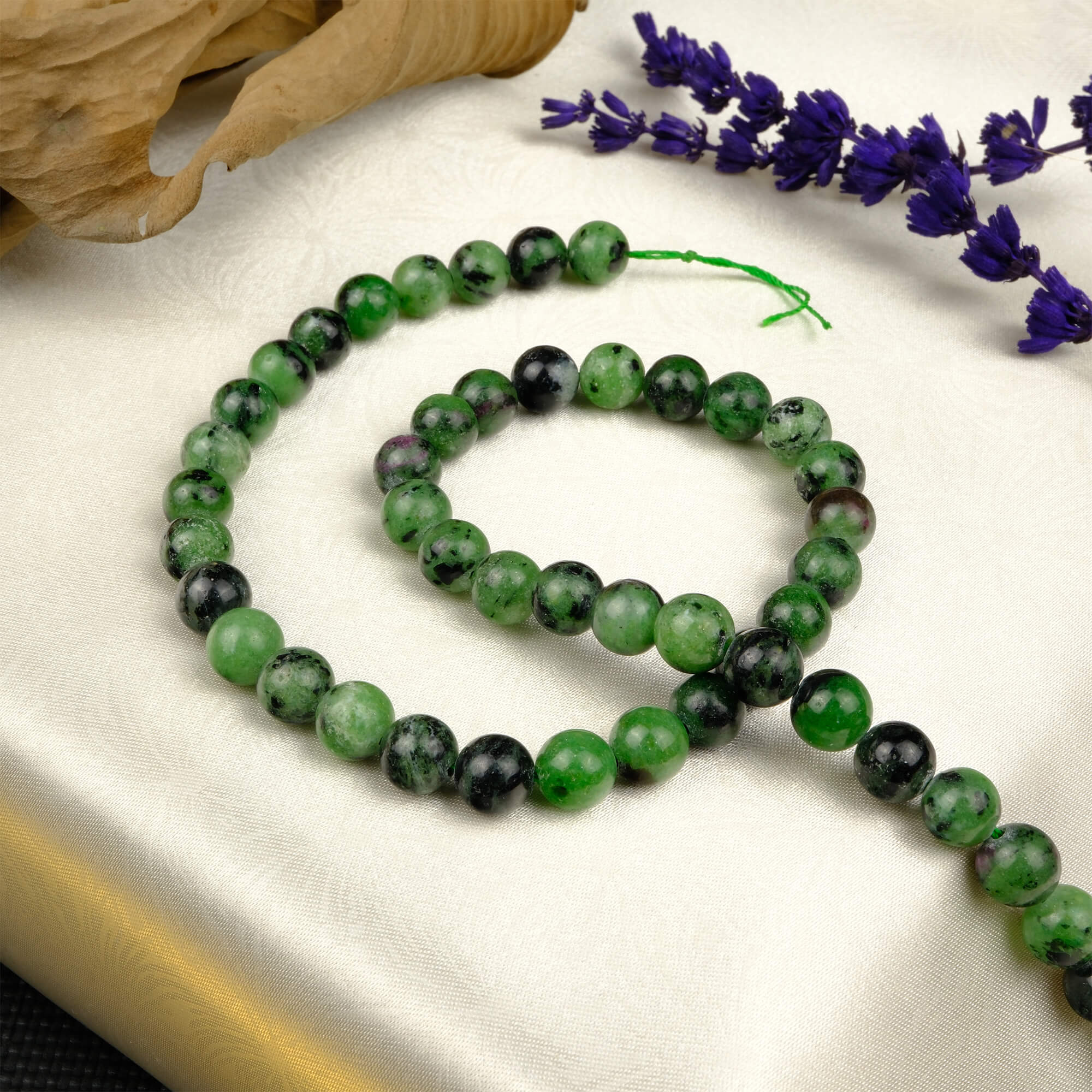 Anyolit 8mm toptan doğal taş dizi – yeşil zemin üzerinde pembe ve mor tonlu desenleriyle canlı bir enerji sunar; bileklik ve kolye tasarımlarında doğal uyum sağlar.