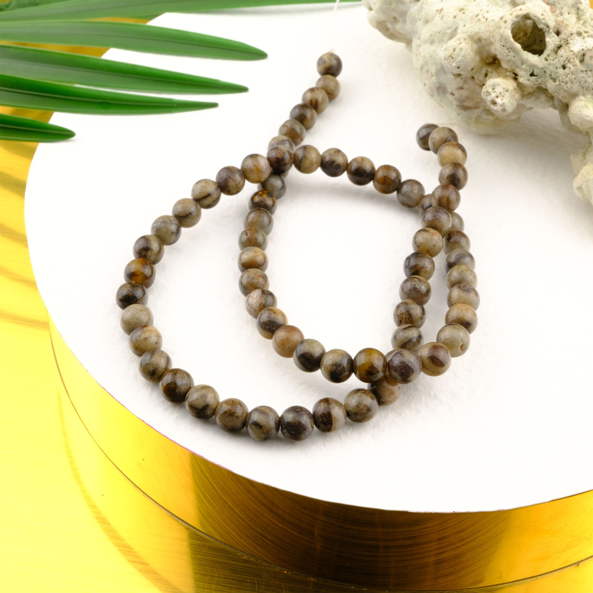 Bronzit taşı, kahverengi ve bronz yansımalarıyla cesaret ve kararlılık enerjisini güçlendiren, dengeleyici etkisiyle öne çıkan toptan doğal taş dizi olarak takı tasarımlarında tercih edilir.