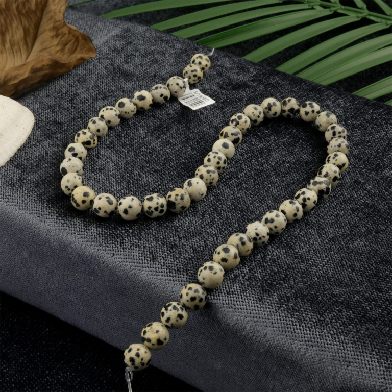Dalmaçyalı Jasper doğal taş dizi 8mm – krem zemin üzerindeki siyah benekleriyle denge, sadakat ve pozitif enerji sağlayan toptan doğal taş dizi.