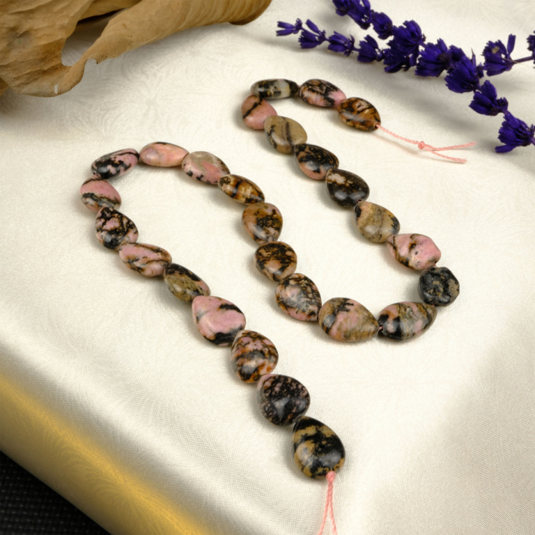 Rodonit doğal taş dizi – pembe tonları ve siyah damar desenleriyle sevgi, denge ve kalp enerjisini güçlendiren zarif bir toptan doğal taş dizi.