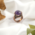 Ametist doğal taş bakır yüzük, bakırın enerji iletkenliği ve sıcak estetik yapısıyla ametist taşının derin mor tonlarını bir araya getirir; yüzük formundaki bu özel tasarım, dengeli frekansı ve zarif duruşuyla toptan doğal taş yüzük arayanlar için güçlü ve zamansız bir takı seçeneğidir.