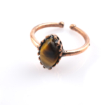 Kaplangözü doğal taş bakır yüzük, bakırın enerji iletkenliğiyle kaplangözü taşının altın kahve yansımalarını bir araya getirir; estetik duruşu ve dengeleyici etkisiyle toptan doğal taş yüzük arayanlar için güçlü bir takıdır.