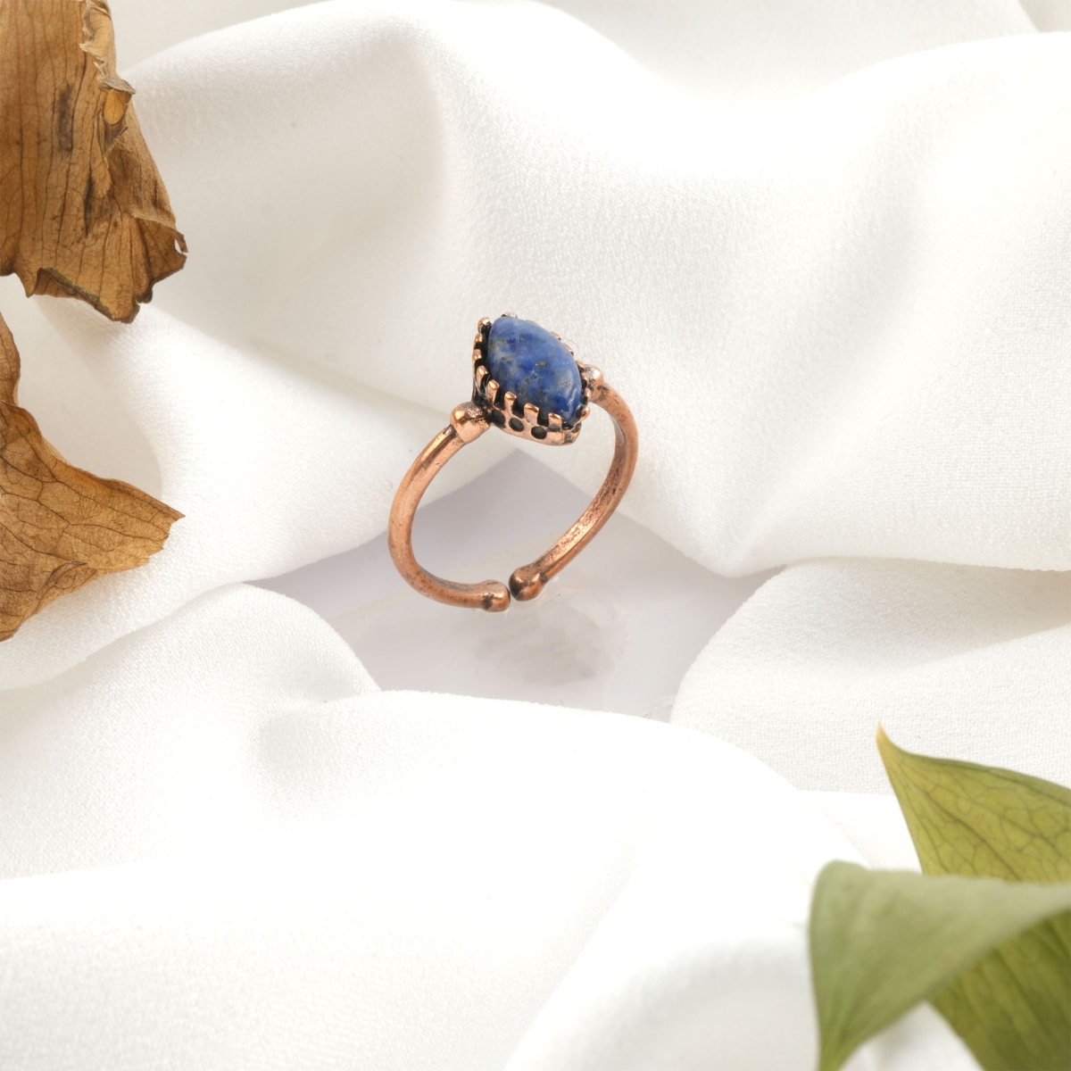 Lapis lazuli doğal taş bakır yüzük, bakırın yüksek enerji iletkenliği ve sıcak estetik yapısıyla lapis lazuli taşının lacivert zemin üzerindeki altın tonlu pirit yansımalarını bir araya getirir; yüzük formundaki bu asil tasarım, dengeli frekansı ve güçlü duruşuyla toptan doğal taş yüzük arayanlar için estetik ve enerjiyi birlikte sunar.