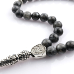 Toptan doğal taş spektrolit tesbih, koyu zemin üzerinde mavi ve yeşil ışık yansımalarıyla farkındalık ve koruyucu enerji sunan, manevi kullanım ve koleksiyon için ideal doğal taş tesbih