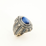 Anello da uomo in argento 925 con una pietra naturale di zaffiro stella originale con taglio cabochon ovale e contorno magistralmente inciso.