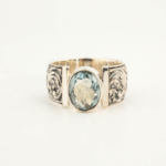 Bague pour homme en argent 925 ornée d'une pierre naturelle d'aigue-marine originale de taille facette ovale et d'un entourage magistralement gravé.