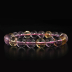 A luxury flexible natural stone bracelet made of 10-11mm round smooth ametrine beads showing purple and yellow color zones.