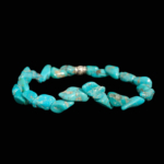 A trendy flexible natural stone bracelet made of organic asymmetrical turquoise chips with an ornate silver-plated spacer.