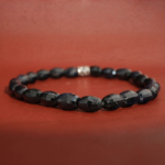 A luxury flexible natural stone bracelet made of 5,5x8,5mm faceted cut dark blue sapphire beads with silver accent.