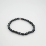 Bracelet flexible en pierre naturelle fait de perles de saphir bleu fonce de 5,5x8,5mm coupe facette avec un accent en argent.