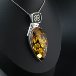 Collar de colección hecho a mano en plata de ley 925 con una piedra de ámbar natural original en forma de gota, decorado con esmalte verde oscuro y elegantes motivos de plata.