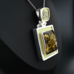 Collier de collection en argent sterling 925 fabriqué à la main avec une pierre d'ambre naturelle originale, décoré d'un travail en émail vert pistache et d'élégants motifs en argent.