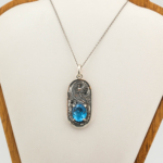 Oval faset kesim orijinal blue topaz doğal taşlı ve çevresi el işçiliği gravürlü 925 ayar gümüş kolye.
