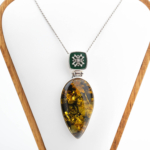 Collier de collection en argent sterling 925 fabriqué à la main avec une pierre d'ambre naturelle originale en forme de goutte, décoré d'un travail en émail vert foncé et d'élégants motifs en argent.