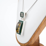 Collier de collection en argent sterling 925 fabriqué à la main avec une pierre d'ambre naturelle originale de forme rectangulaire verticale, décoré d'un travail en émail vert foncé et d'élégants motifs en argent.