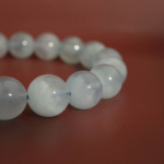 Bracelet flexible en pierre naturelle fait de perles rondes et lisses d'aigue-marine bleu clair translucide de 10-11mm.