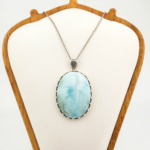 Collier en argent 925 orné d'une pierre naturelle de larimar original de taille cabochon ovale grand format et de gravures faites à la main.