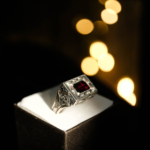 Herrenring aus 925er Sterlingsilber mit einem rechteckig facettierten originalen Granat-Naturstein in einem quadratischen Rahmen mit handgefertigten floralen Motiven.