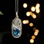 Collier en argent 925 orné d'une pierre naturelle de topaze bleue originale de taille facette ovale et d'un entourage magistralement gravé.