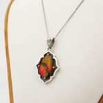 Collana in argento 925 con una pietra naturale di opale ammonite bodrial originale con riflessi ardenti rossi e verdi e motivi dettagliati fatti a mano.