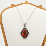 Halskette aus 925er Sterlingsilber mit einem originalen Ammonit-Bodrial-Opal-Naturstein mit roten und grünen feurigen Reflexen und detaillierten handgefertigten Motiven.