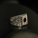 Anillo de hombre de plata 925 con una piedra natural de granate original de talla faceta octogonal en un marco cuadrado con motivos florales hechos a mano.