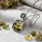 Collectible handcrafted 925 sterling silver necklace with an original natural amber stone, decorated with dark green enamel work and elegant silver motifs.