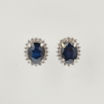 A luxury designer earrings made of original oval cut blue sapphire gemstones set in a 925 sterling silver halo with sparkling zircon accents.