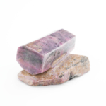 Morceau de pierre naturelle de rubis brut original dans des tons roses et rouges sur matrice naturelle.
