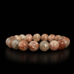 A luxury flexible natural stone bracelet made of 10-11mm round smooth clear quartz beads with multi copper rutilated inclusions.