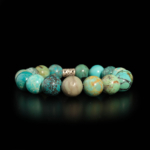 A luxury flexible natural stone bracelet made of large round veined turquoise beads with a silver-plated spacer.