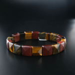 Bracciale flessibile in pietra naturale taglio rolex realizzato con pietre di occhio di tigre originali nei toni dell'oro, del rosso e del blu.