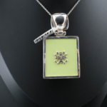 Collana da collezione realizzata a mano in argento sterling 925 con pietra d'ambra naturale originale, decorata con smalto verde pistacchio ed eleganti motivi in argento.