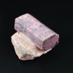 Original rå rubin naturstensbit i rosa och röda toner på naturlig matris.