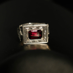 Anillo de hombre de plata 925 con una piedra natural de granate original de talla faceta rectangular en un marco cuadrado con motivos florales hechos a mano.