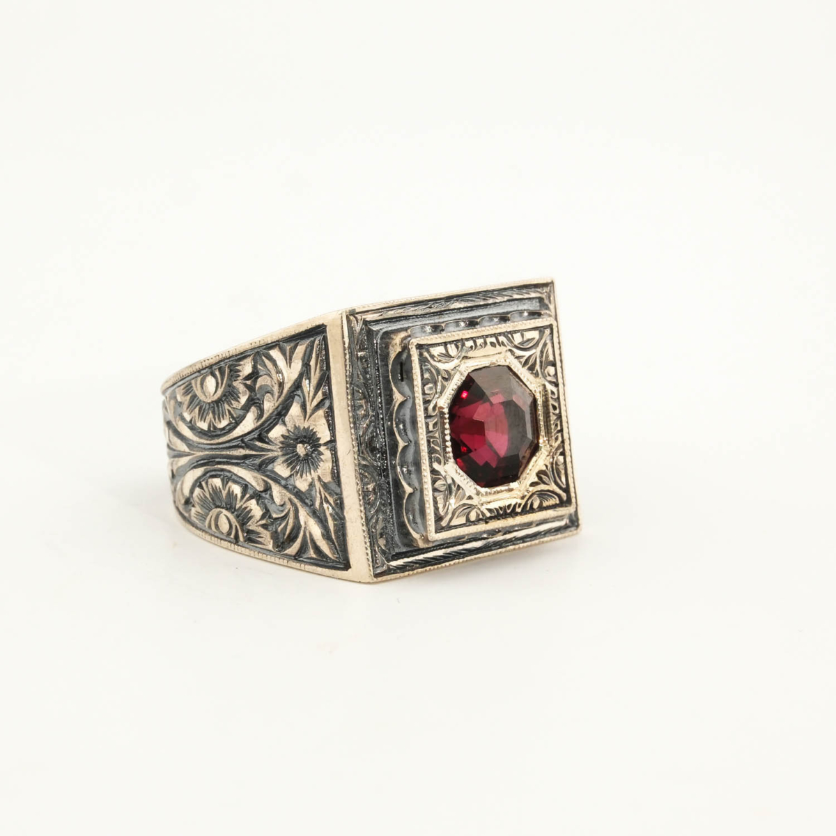 Anello da uomo in argento 925 con una pietra naturale di granato originale con taglio a faccette ottagonale in una cornice quadrata con motivi floreali fatti a mano.