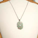 Colgante de diseño de lujo en plata de ley 925 con piedras de esmeralda verde naturales de corte facetado ovalado y detalles de circonitas.