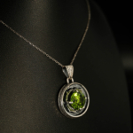 Collar de plata 925 con una piedra natural de peridoto original de corte redondo y detalles de garras en forma de pétalo de flor.