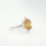 A luxury women's statement ring featuring a 4.10ct oval-cut original yellow sapphire gemstone surrounded by a starry marquise cubic zirconia halo in 925 sterling silver.
