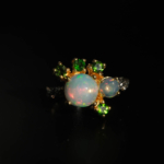 Anillo de diseño de lujo en plata de ley 925 con detalles en oro, adornado con una gema de ópalo natural y tsavoritas de corte faceteado.