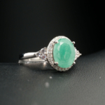 Bague d'élégance pour femme ornée d'une émeraude naturelle originale entourée de zircons sur monture en argent 925.