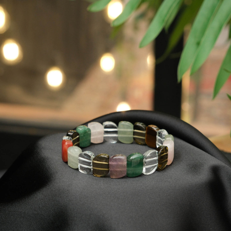 A luxury statement chakra bracelet featuring original rolex-cut natural gemstone beads on a stretch band.