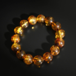 A luxury statement gemstone bracelet featuring certified original 14-15mm adult Baltic amber round beads on a stretch band.