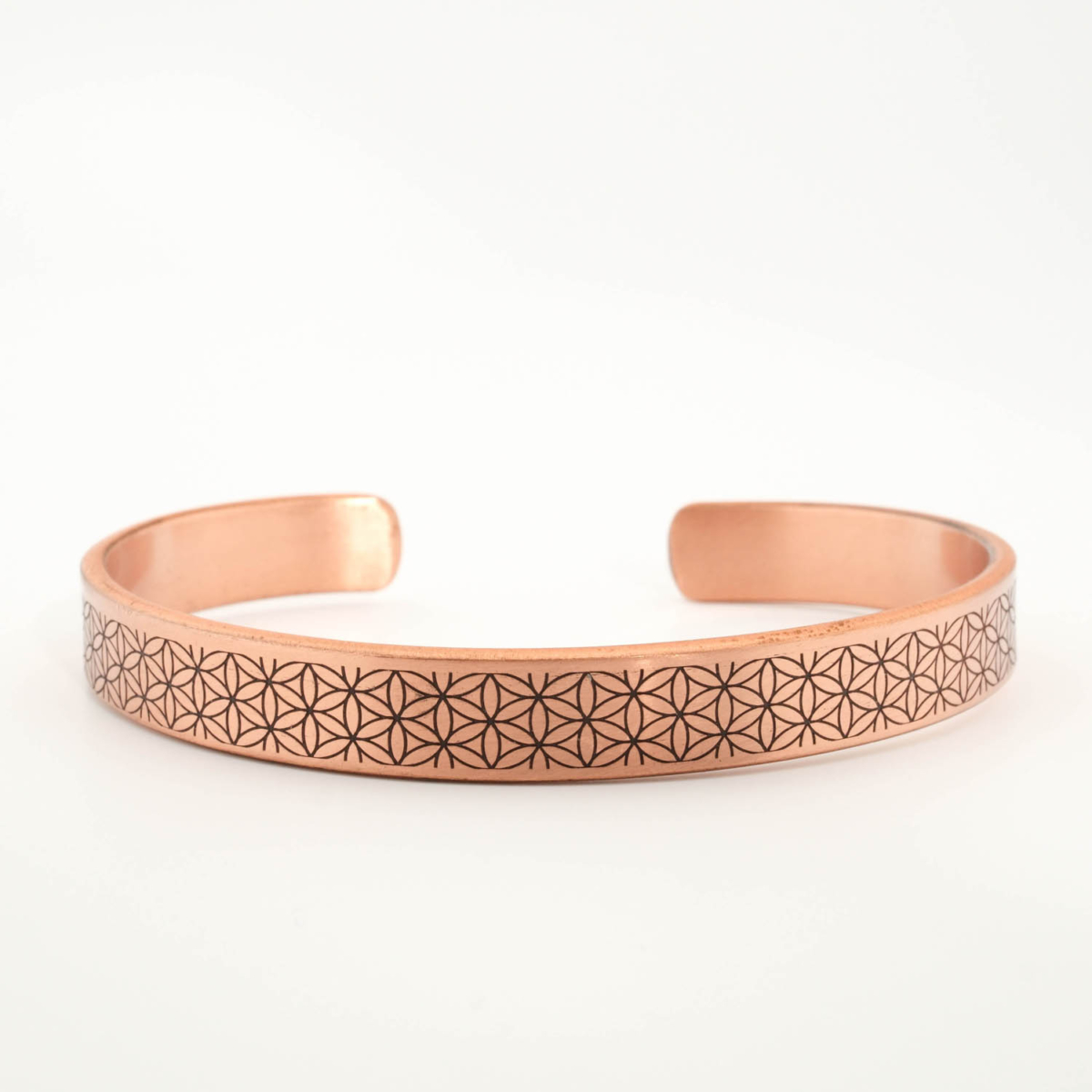 A luxury handcrafted pure copper cuff bracelet featuring an engraved flower of life pattern on the outside and Ayat al-Kursi inside.