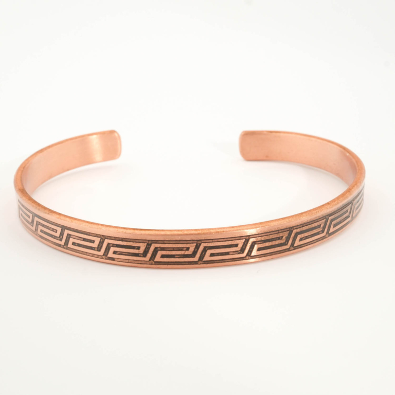 A handcrafted thin pure copper cuff bracelet featuring an engraved Greek key meander pattern with black oxidation.