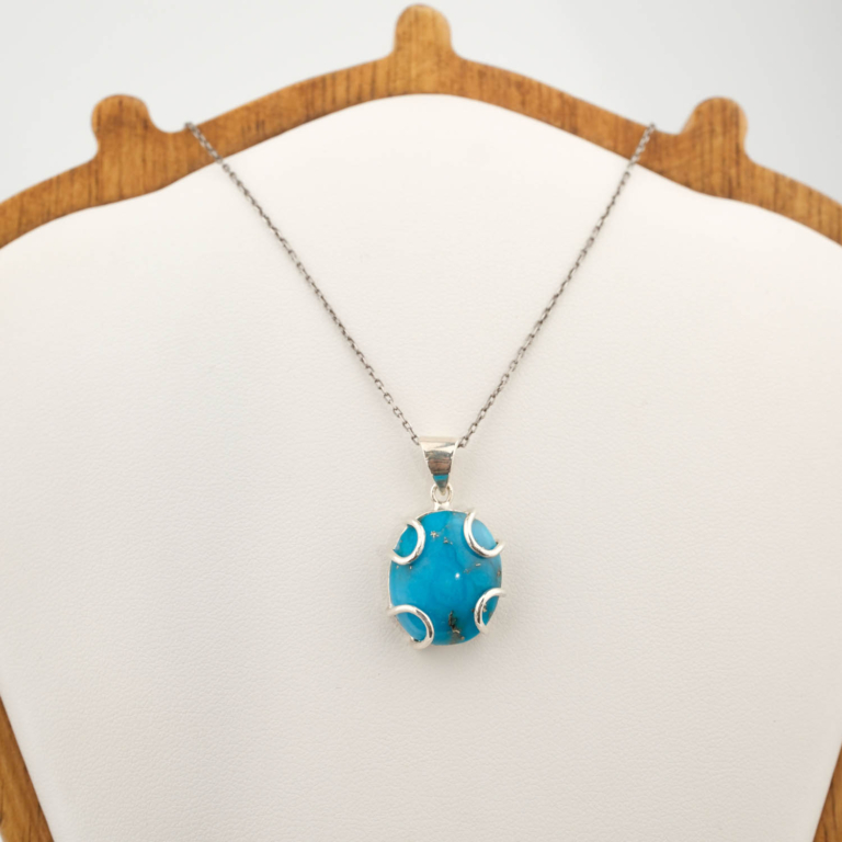 A luxury natural stone necklace featuring an original oval cabochon turquoise gemstone set in a 925 sterling silver artisan pendant.